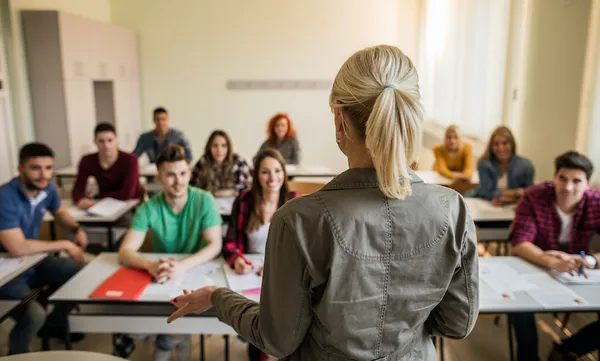 Back view of teacher during a lecture in the classroom.