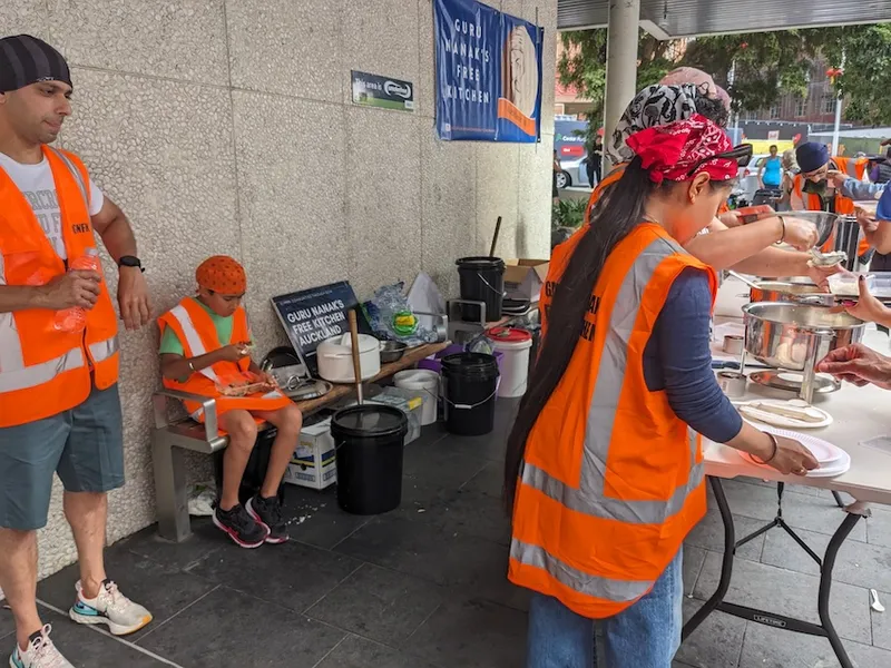 volunteers in high vis vests serve food