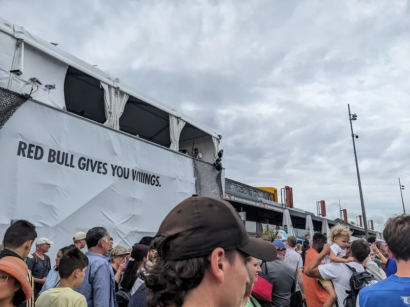 the heads of a lot of people and a poster that says red bull gives you wiiiiiiiings