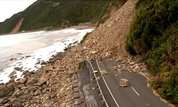 a narrow highway by some rugged coast, with a huge slip completely covering the road