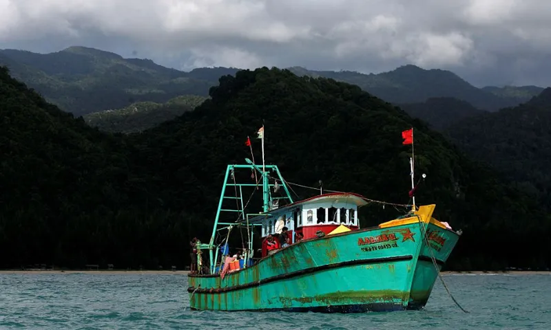a green boat under a stormy sky with hills in the backgroun