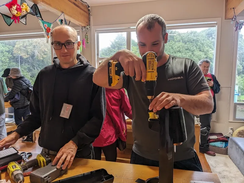 two men, one crilling a new screw into a carbonating machine