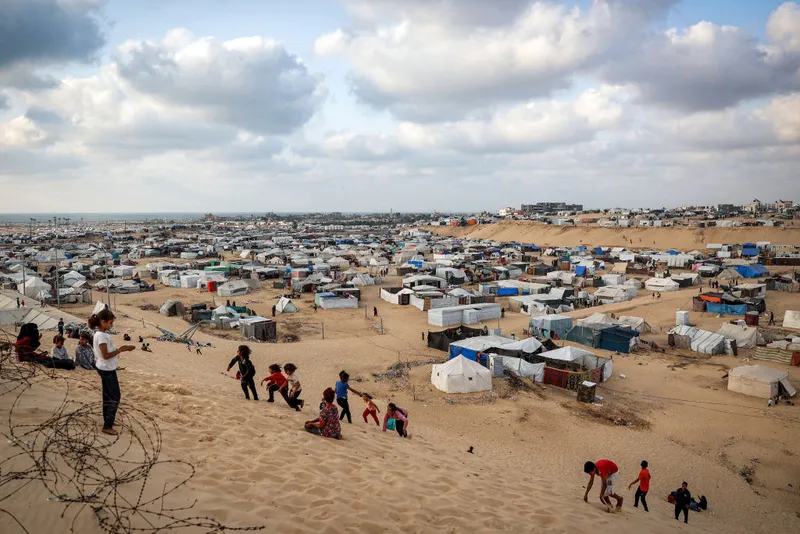 Children play along a slope near a camp housing displaced Palestinians in Rafah in the southern Gaza Strip on April 30, 2024, amid the ongoing conflict in the Palestinian territory between Israel and the militant group Hamas. (Photo by AFP) (Photo by -/AFP via Getty Images)