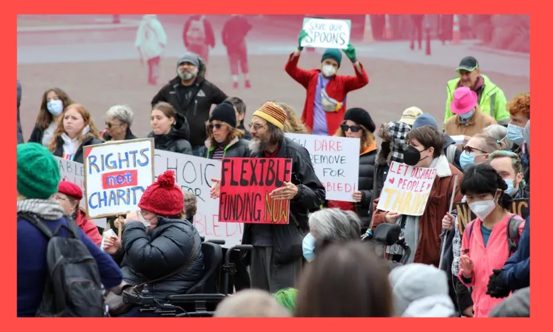 a group of people hold signs protesting disability cuts with humorous slogans, the background is faded out and there isa red border around the image