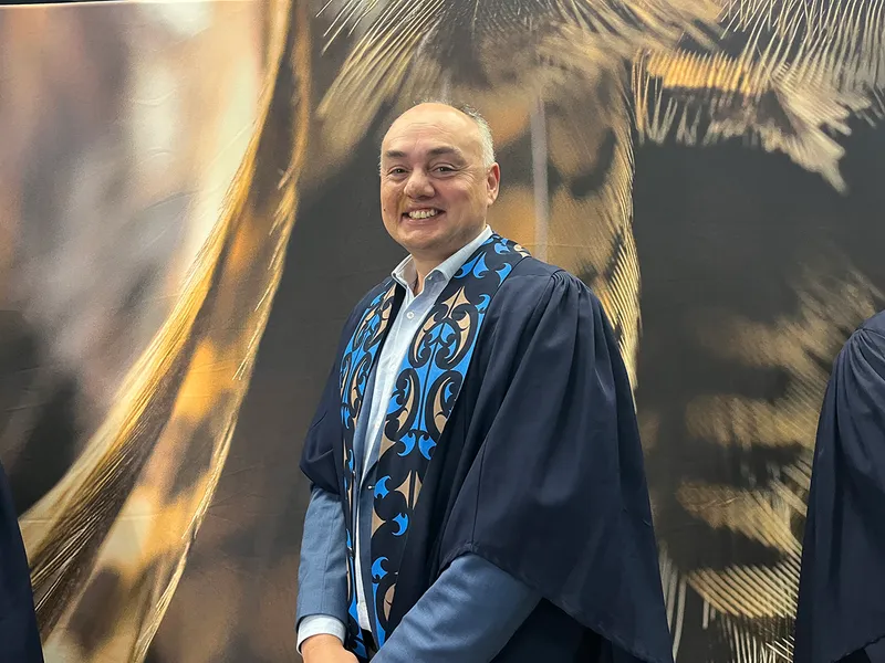 Man in graduation regalia.