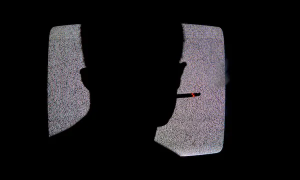 Silhouette Of Man Smoking Cigarette And Watching Television In Dark