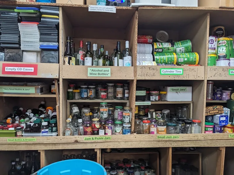 a shelf of empty jars and tins in various sizes, neatly labelled