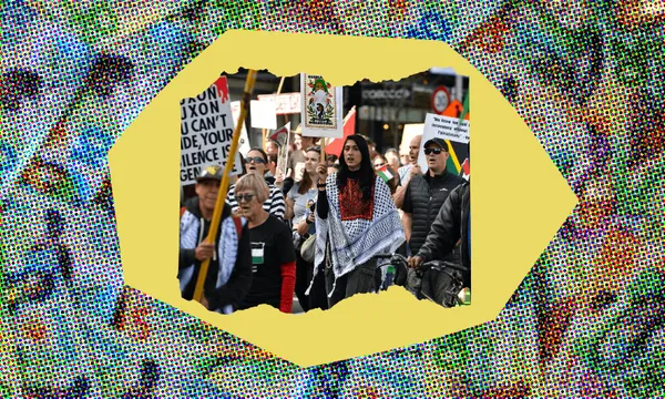 A group of people holding protest signs march in a demonstration. The scene is framed by a colourful, dotted pattern.