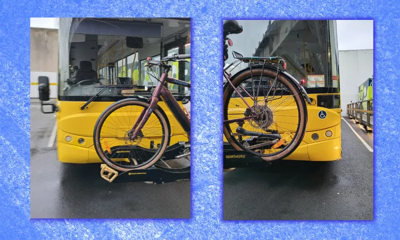 a blue textrued road background with a bike mounted on a yellow bus in wellington in better times