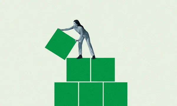 Young woman building green block pyramid