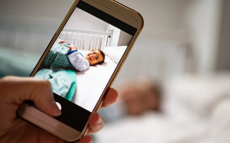 Parent taking photo of a baby with smartphone