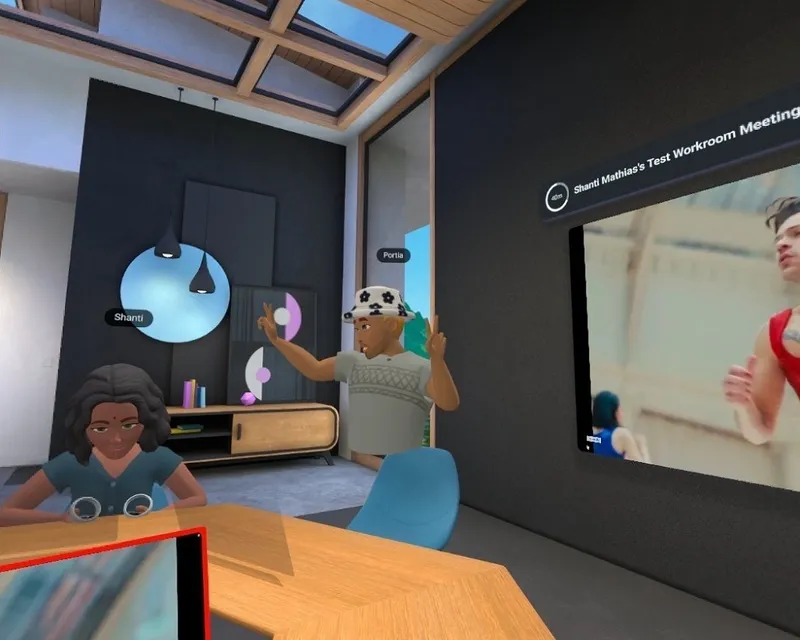 slightly chaotic scene of an animated room with a legless body labelled portioa and a brown skinned cartoon avatar called shanti sitting at a desk. part of Harry Styles As it Was music video plays in the background