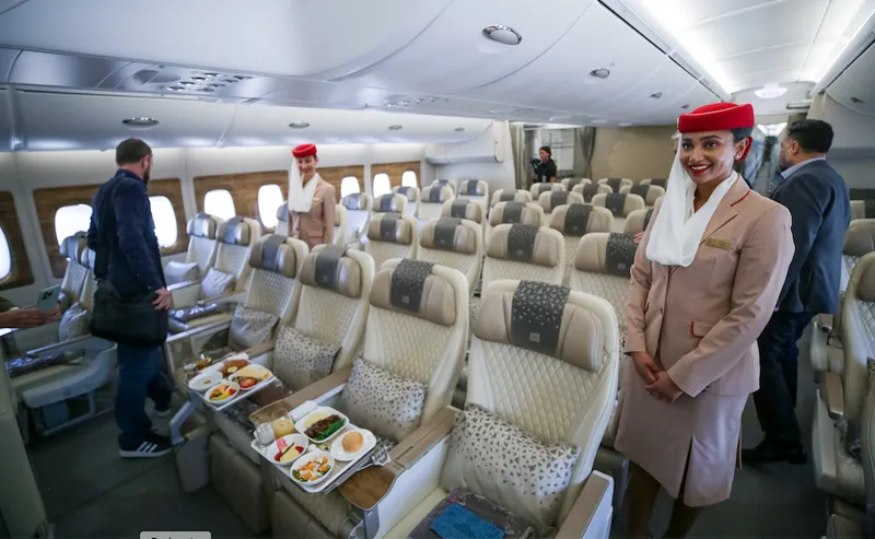 Hosts and journalists mingle on an A380 plane.