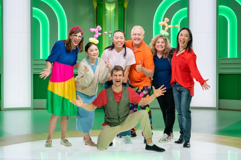 The Blow Up contestants stand together smiling at the camera, arms outstretched