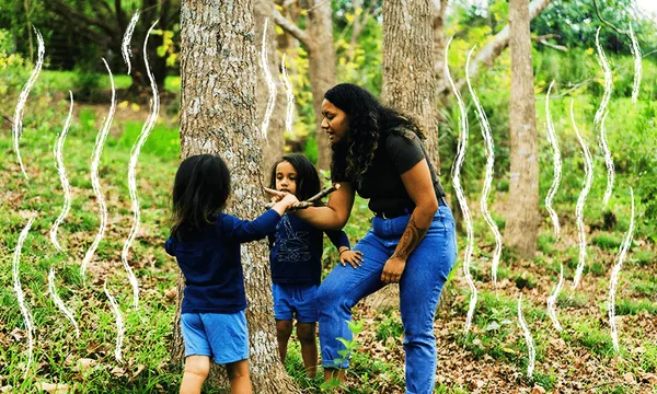 a woman and two kids, all in black and blue, around a tree with white squiggly lines to give it a sense of the world beyond the literal one