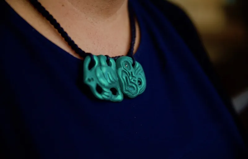 a woman with a hei tiki around her neck in muted colors