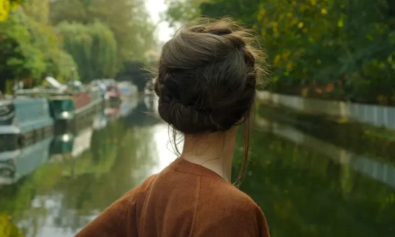 The back of a woman's head as she travels down a canal –A still from the trailer for Anchor and Hope, a movie about lesbians living on a houseboat