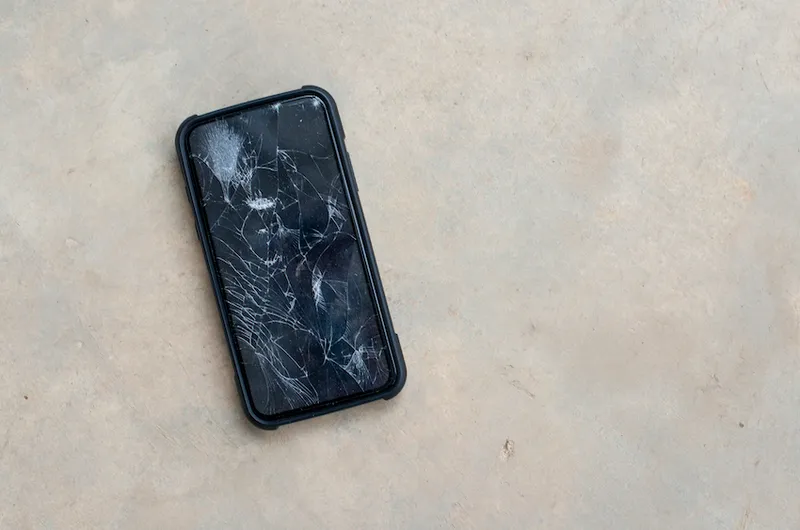 The phone screen is cracked.