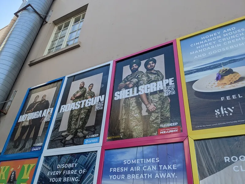 a beige wall with people in uiform for on posters for the code words campaign reading Shellscrape, roastgun, Mo'anga afi"