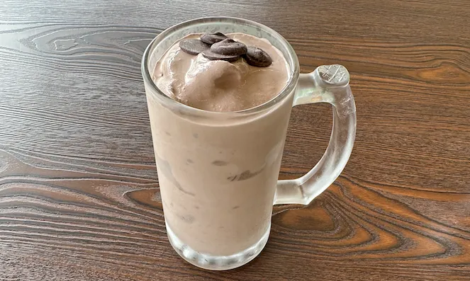 A chocolate shake sprinkled with chocolate buttons.