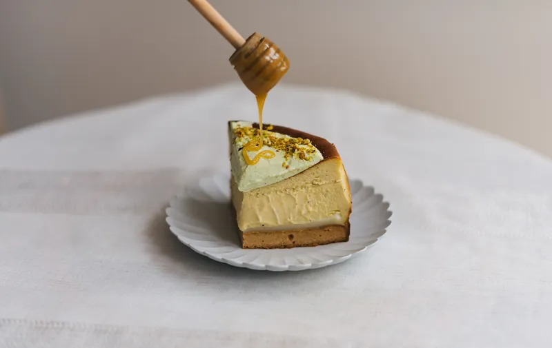 A slice of cheesecake drizzled in honey.