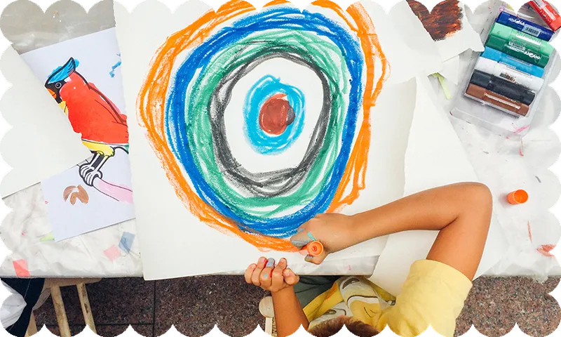 a wavy border around a top-down photo of a kid drawing