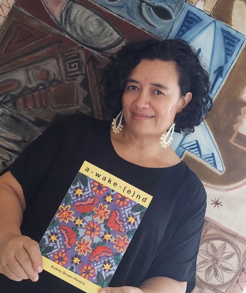 Audrey Brown Pereira holding her book A-wake-(e)nd