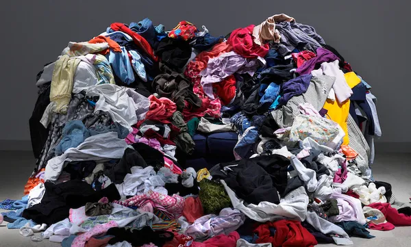 Sofa buried under piles of clothes
