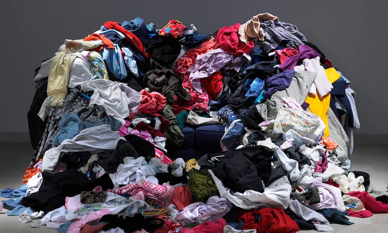 Sofa buried under piles of clothes