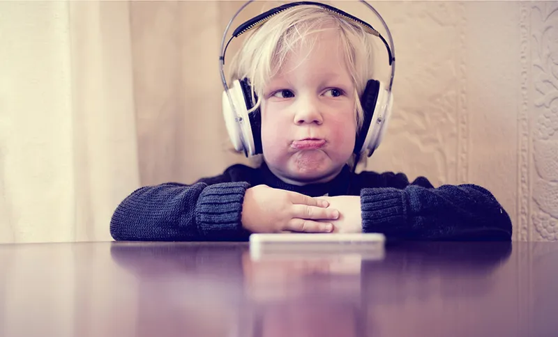 Child with sad face and headphones on