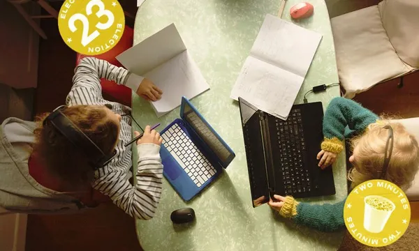 two kids looking at books and computers on a table with an election 2023 spinoff logo on top