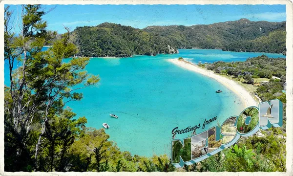 An aerial shot of an azure-blue beach in Motueka, near Nelson, New Zealand. Overlaid text says "Greetings from Nelson"