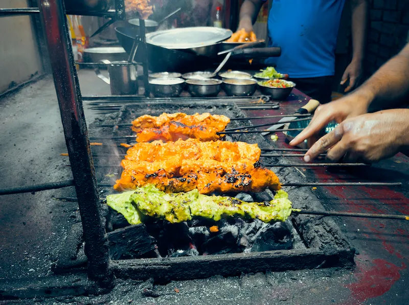 Preparing of tanddori chicken tikka kebab and green hariyali kebab at a roadside street food stall in Kolkata
