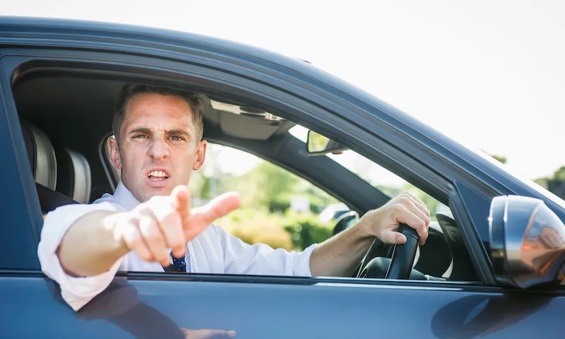 Angry businessman shouting out car window