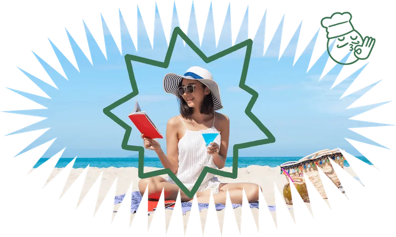 Woman ecstatically reading on beach - she's sitting cross-legged, wearing a giant hat, holding a book in one hand and cocktail in the other.