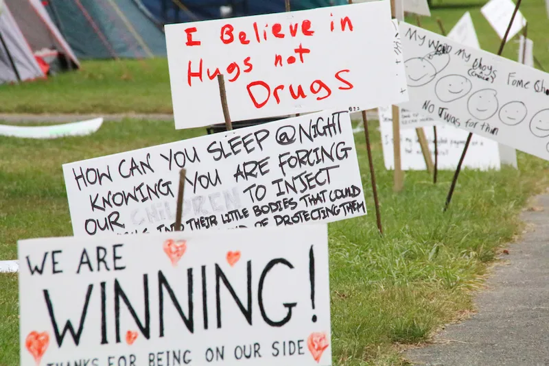 Signs with anti-mandate protester slogans line up along the