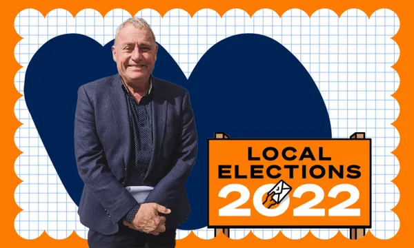 phil mauger, white man in a blue suit, on blue background with a local elections 2022 sign and a smile