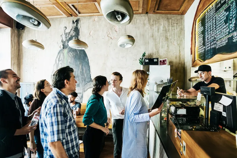 People Waiting In Line In Busy Burger Restaurant