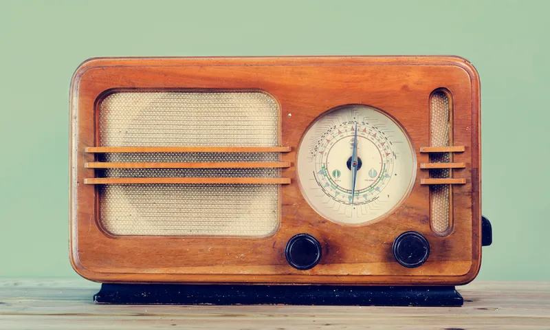 Close-Up Of Old Radio On Table Against Green Background
