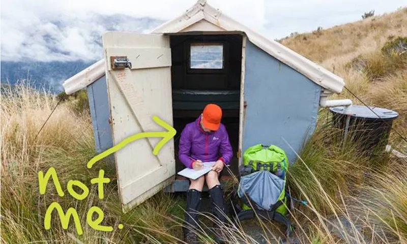 A hiker in front of a hut, with 'not me' written on it
