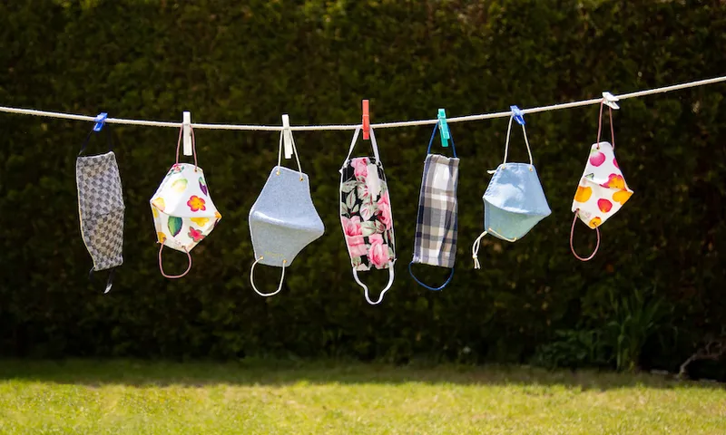 Colourful corona masks in the garden hung up on a leash
