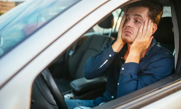 A young man desperately waits in the traffic jam
