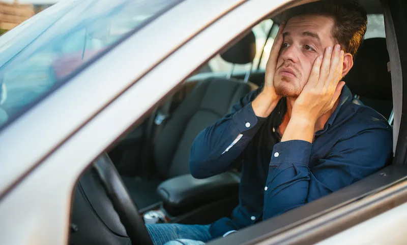 A young man desperately waits in the traffic jam