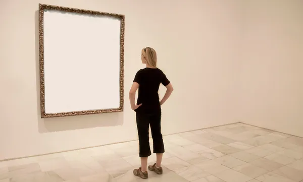 Young lady looking at blank art frame.
