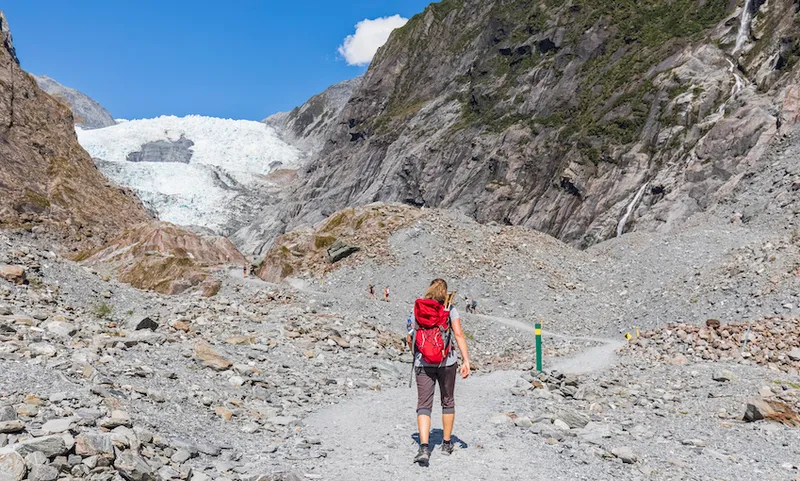 New Zealand, Westland District, Franz Josef, Female backpacker hiking in Franz Josef Glacier