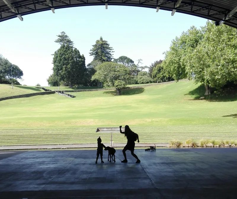 Yahoo! We're inside a soundshell in a park, looking out at a woman, a child and a dog silhouetted against the light. The woman and child are punching the air in celebration.
