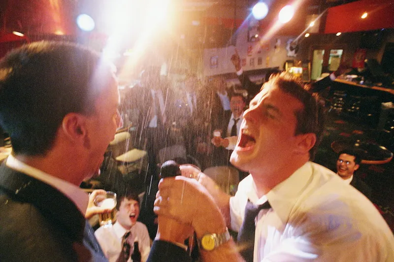 Two businessmen singing on stage in nightclub
