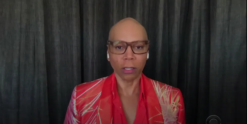 RuPaul in front of curtains