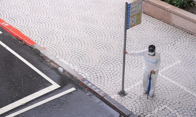 A masked man at a bus stop in Taipei