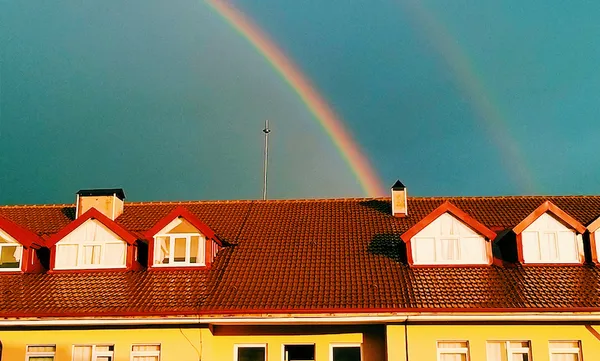 Rainbow Over Houses And Building Against Sky